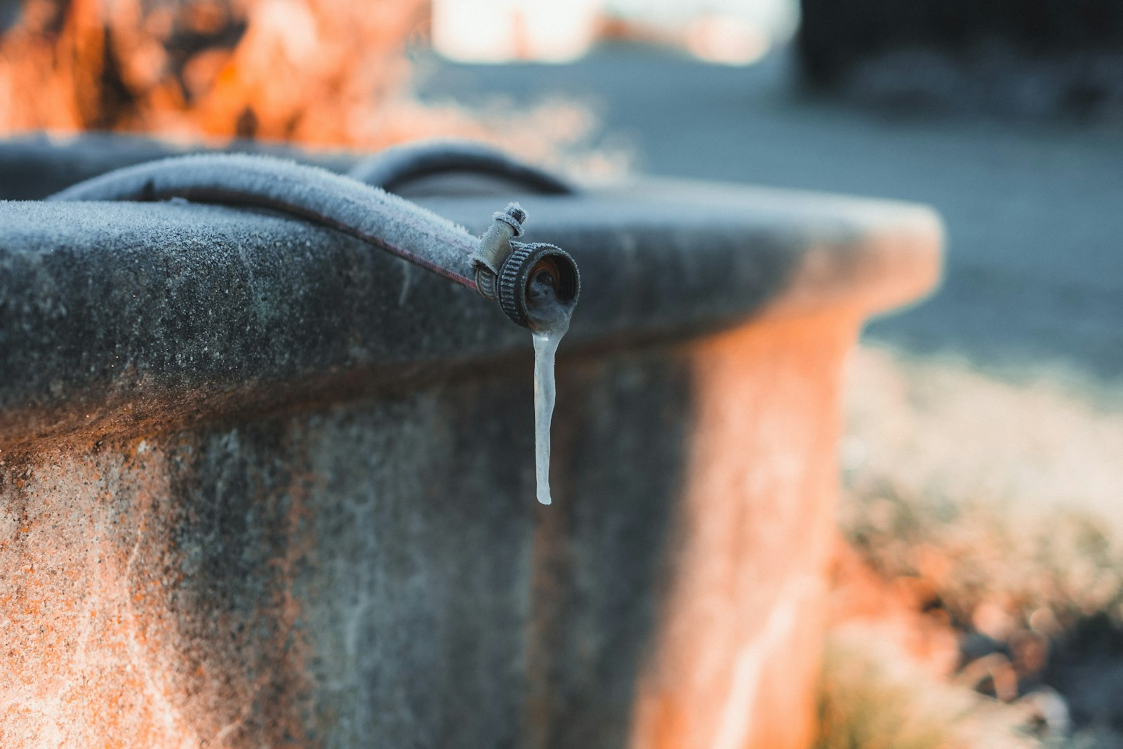 Icicle hanging from a frozen metal spout