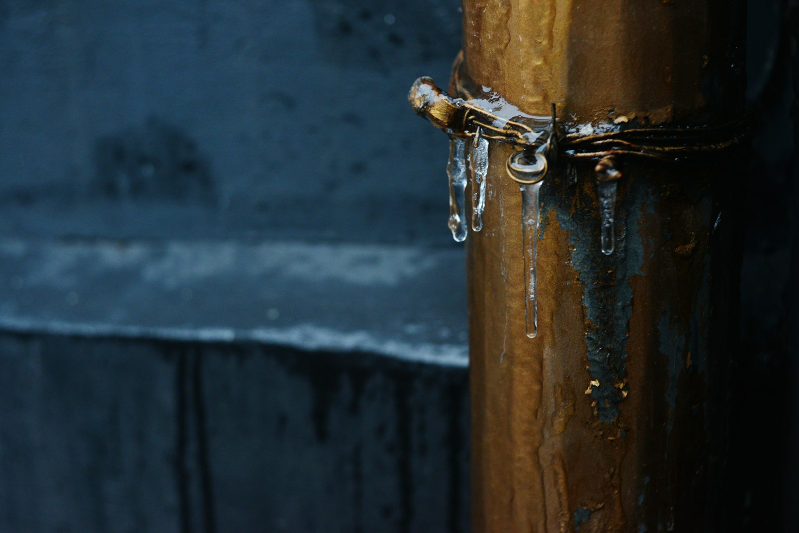 Icicles hanging from a frozen outdoor pipe