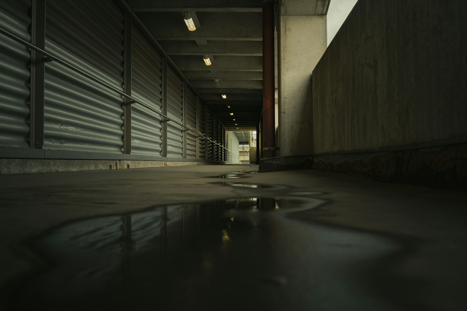 Standing water on the floor of a dark corridor