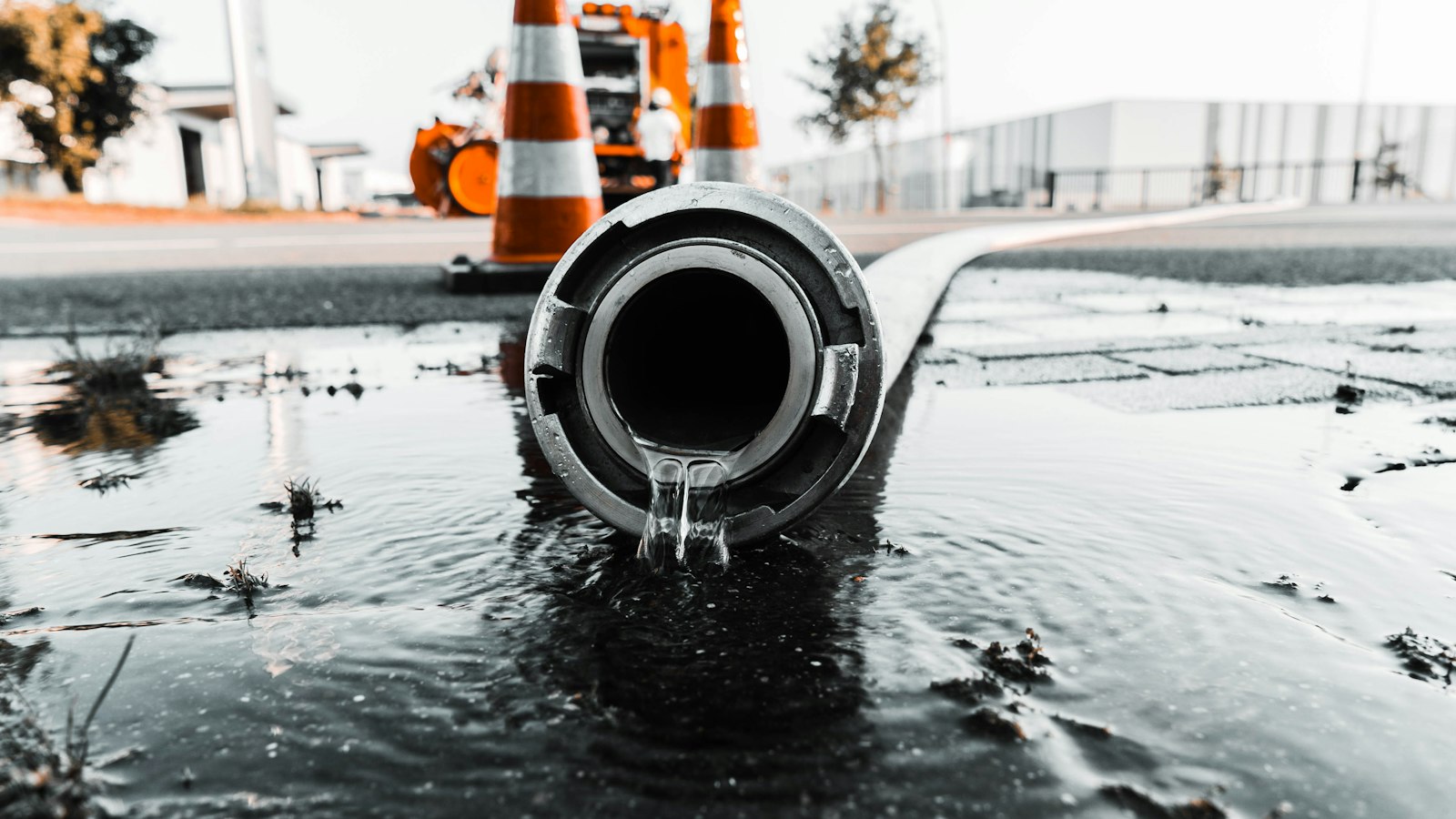 Water flowing from a large pipe beside roadworks