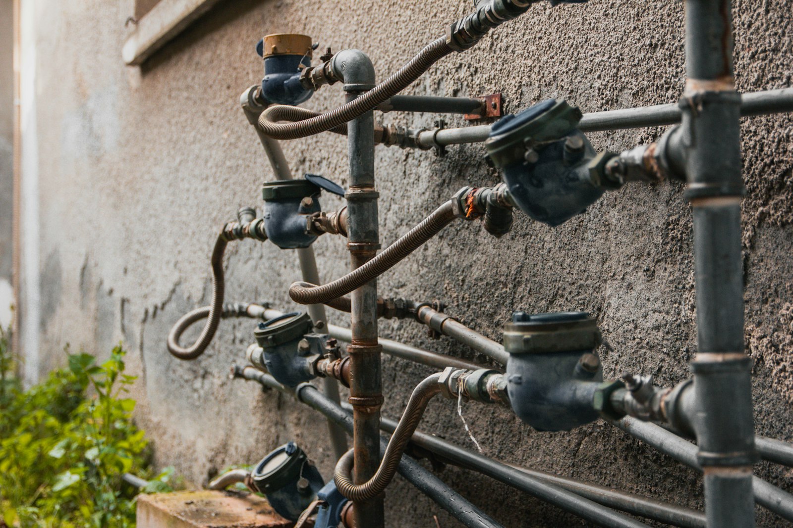 Several water meters fitted to pipework on a wall