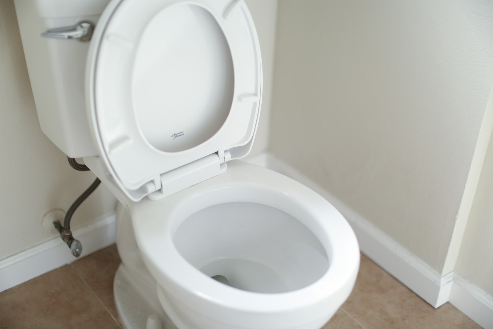 White toilet with the seat raised in a bathroom